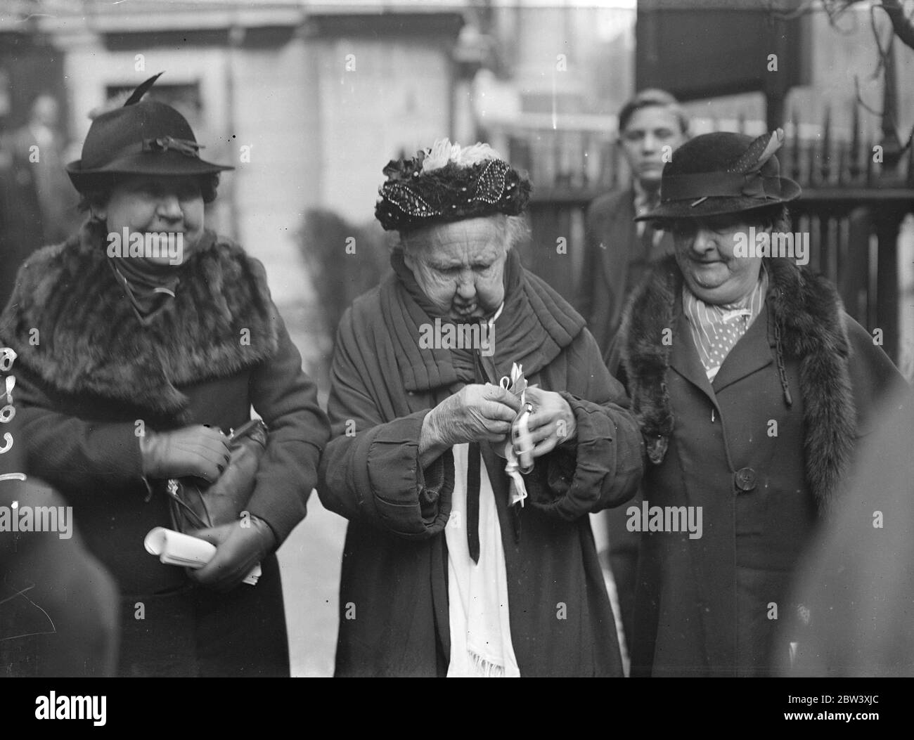 Il primo lotto di conio di Giorgio VI coniato appositamente per l'adesione, fu distribuito dall'arcivescovo di Canterbury, come Lord High Almoner , durante la cerimonia annuale di Maundy Money nella Cattedrale di San Paolo. La distribuzione è stata fatta a 42 uomini e 42 donne corrispondenti agli anni dell'età del re. La cerimonia è stata trasferita a St Pauls mentre l'Abbazia di Westminster è chiusa per le alterazioni dell'incoronazione. Foto: I destinatari con i loro soldi Maudy dopo la cerimonia. 25 Marzo 1937 Foto Stock