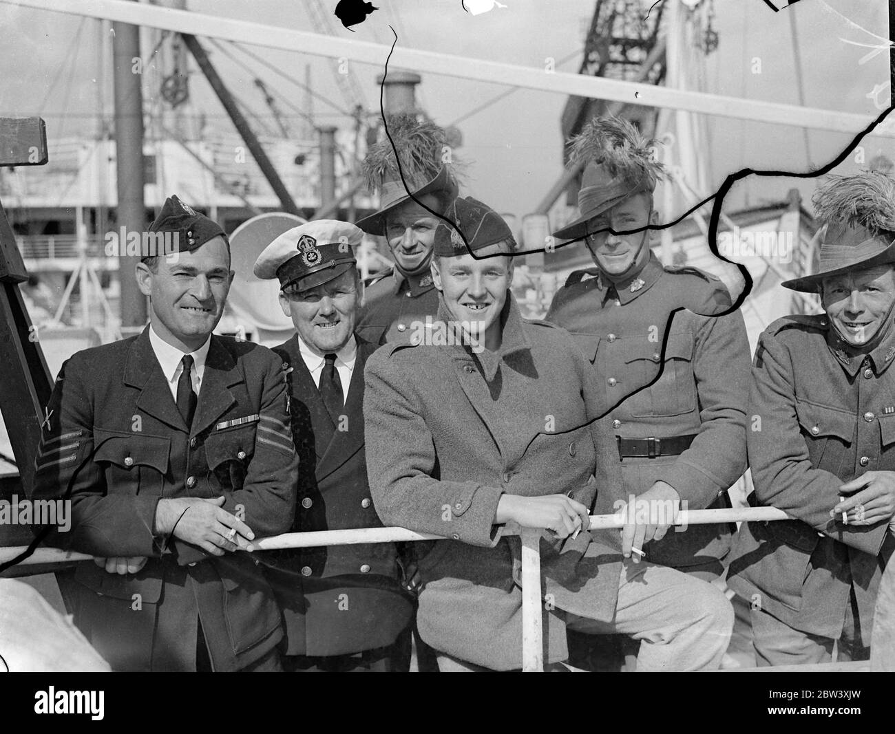 Stowing via a Gibilterra dopo essere stato ferito nel polmone e nel braccio quando combatteva per le forze governative in Spagna, 24-year-old Norman Knight è arrivato a Southampton a bordo del liner Oronsay . Sulla stessa nave erano membri del contingente australiano per l'incoronazione. Spettacoli fotografici: Norman Knight con i membri dei servizi australiani, con possibilità di arrivo a Southampton. 24 Marzo 1937 Foto Stock