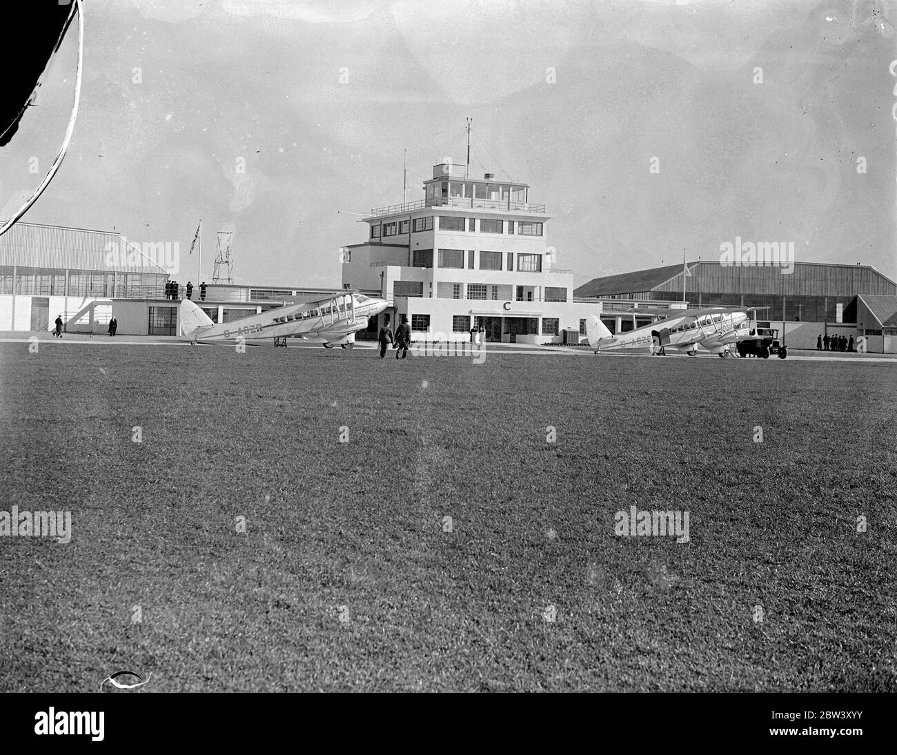 Il nuovo aeroporto di Jersey £ 130 , 000 aperto dalla moglie di Bailiff. Costruito al costo di £ 130, 000 , il nuovo aiproto di Jersey nelle Isole del canale, fu aperto dalla sig.ra Coutanche, moglie del Bailiff di Jersey. Uno dei più belli delle Isole Britanniche , il nuovo aerodromo permetterà di operare nove servizi per ogni tratta rispettivamente tra Jersey , Southampton , Londra , Exeter e Brighton . Circa 700 passeggeri saranno trasportati settimanalmente. Spettacoli fotografici, aerei De Havilland DH86 Express, Ouainé Bay (G-ACZO) e la Saline Bay (G ACZR), sul asfalto. . 10 marzo 1937 Foto Stock