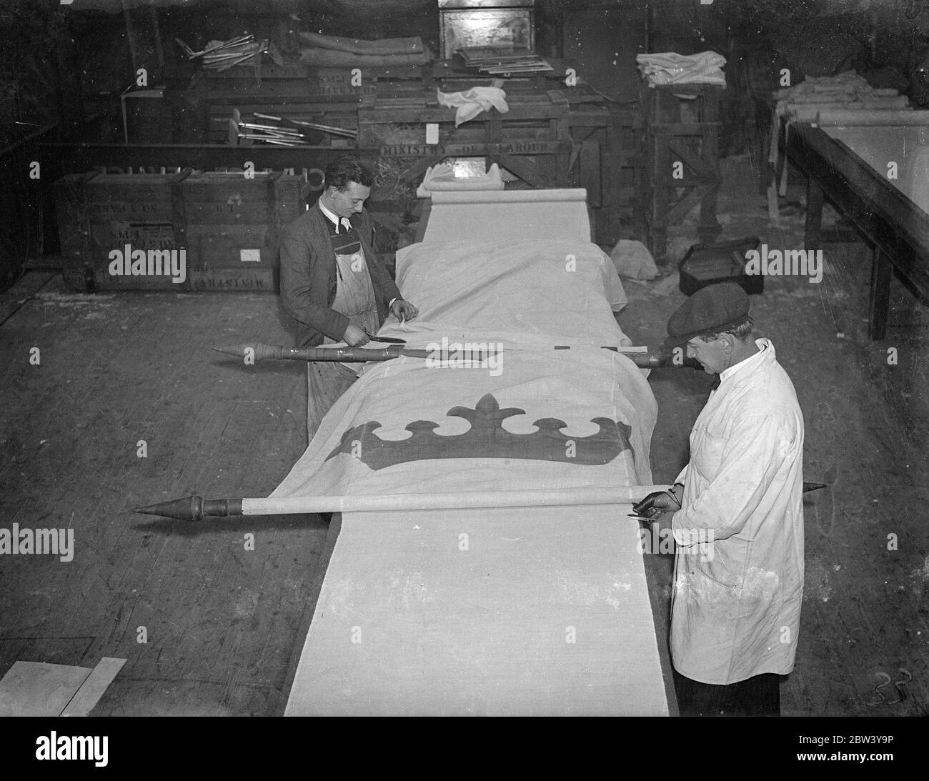 40 banner piedi come decorazioni coronazione nel West End. Foto: Uomini al lavoro in una fabbrica Maida vale, Londra, su uno dei 40 metri di banner che saranno utilizzati per decorare le principali arterie del West End durante le celebrazioni di Coronazione. Con solo nove settimane di tempo prima della Coronation, le fabbriche di Londra stanno lavorando alla massima velocità per far fronte agli ordini. 6 marzo 1937 Foto Stock