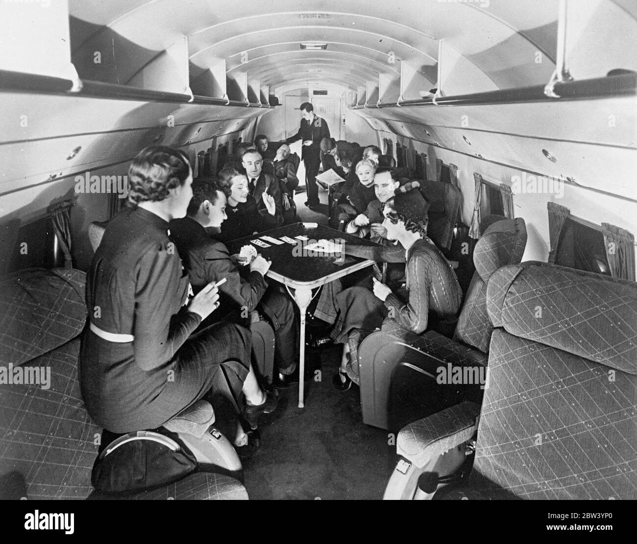 La Regina dell'aria d'America Maria. Comfort a 200 miglia all'ora. Dotato di sedie a rotelle imbottite, aria condizionata, riscaldamento a vapore e telefoni interaerei, un nuovo aereo di linea Douglas da 12 tonnellate, con 21 passeggeri, è stato messo in servizio tra Chicago e New York. Il servizio è programmato per operare senza sosta in quattro ore lungo il percorso di 800 miglia. La cabina è praticamente insonorizzata e il nuovo aereo si dice essere la più lussuosa macchina per passeggeri su qualsiasi servizio. Spettacoli fotografici: I passeggeri giocano a carte nella lussuosa lounge del nuovo aereo di linea americano ad alta velocità da 12 tonnellate. 19 Foto Stock