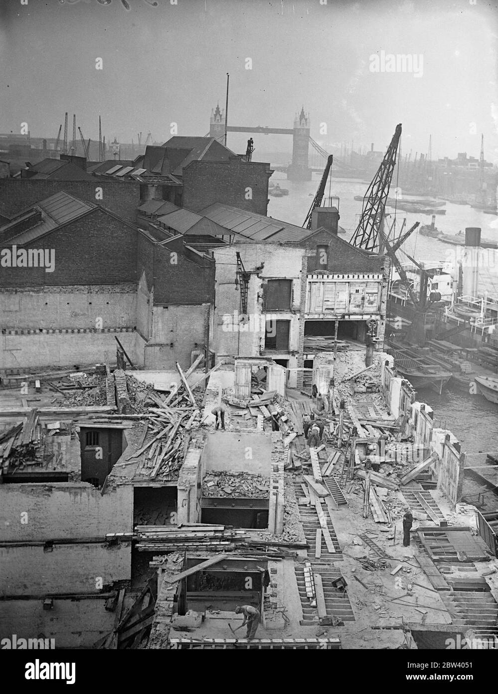 Demolizione e costruzione al London Bridge . Lavori di demolizione e costruzione in corso fianco a fianco all'ombra del London Bridge . Il molo della piscina di Londra è stato ampliato da un'aggiunta a Fresh Wharf e un vecchio magazzino è in fase di demolizione per fare posto a un grande nuovo edificio. Mostre fotografiche, demolendo il vecchio magazzino Fresh Wharf , London Bridge , per far posto al nuovo edificio . 19 settembre 1936 Foto Stock