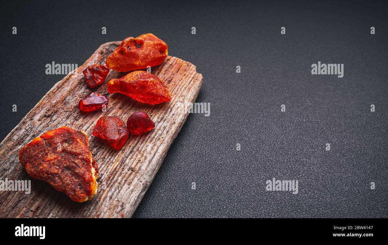 Ambra naturale. Un pezzo di trasparente giallo ambra naturale sul grande pezzo di scuro legno lapidato. Foto Stock