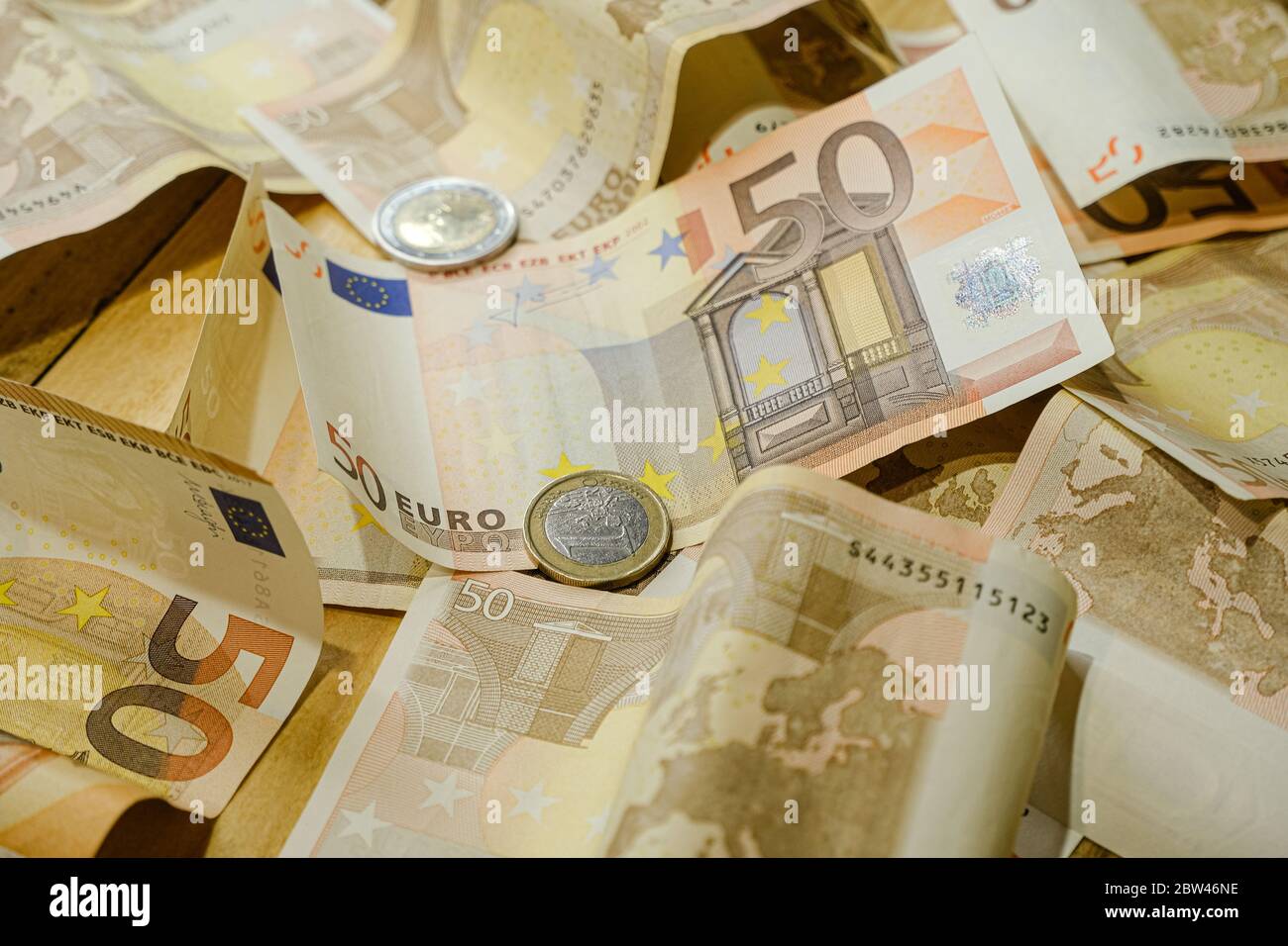 Monete e fatture in euro su un tavolo, soldi di goccia, economia di affari Foto Stock