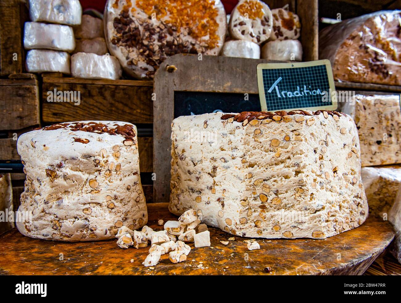 Auf dem Markt von Annecy in Haute-Savoie wird Nougat von riesigen Torten im Stück abgeschniten. Foto Stock