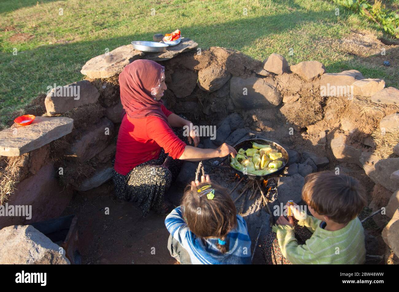 Türkei, Provinz Bingöl, Frau vom Stamm der Beritan-Nomaden an Feuerstelle beim Zubereiten von Essen auf einer Hochweide in den Seraferettin-Berg Foto Stock