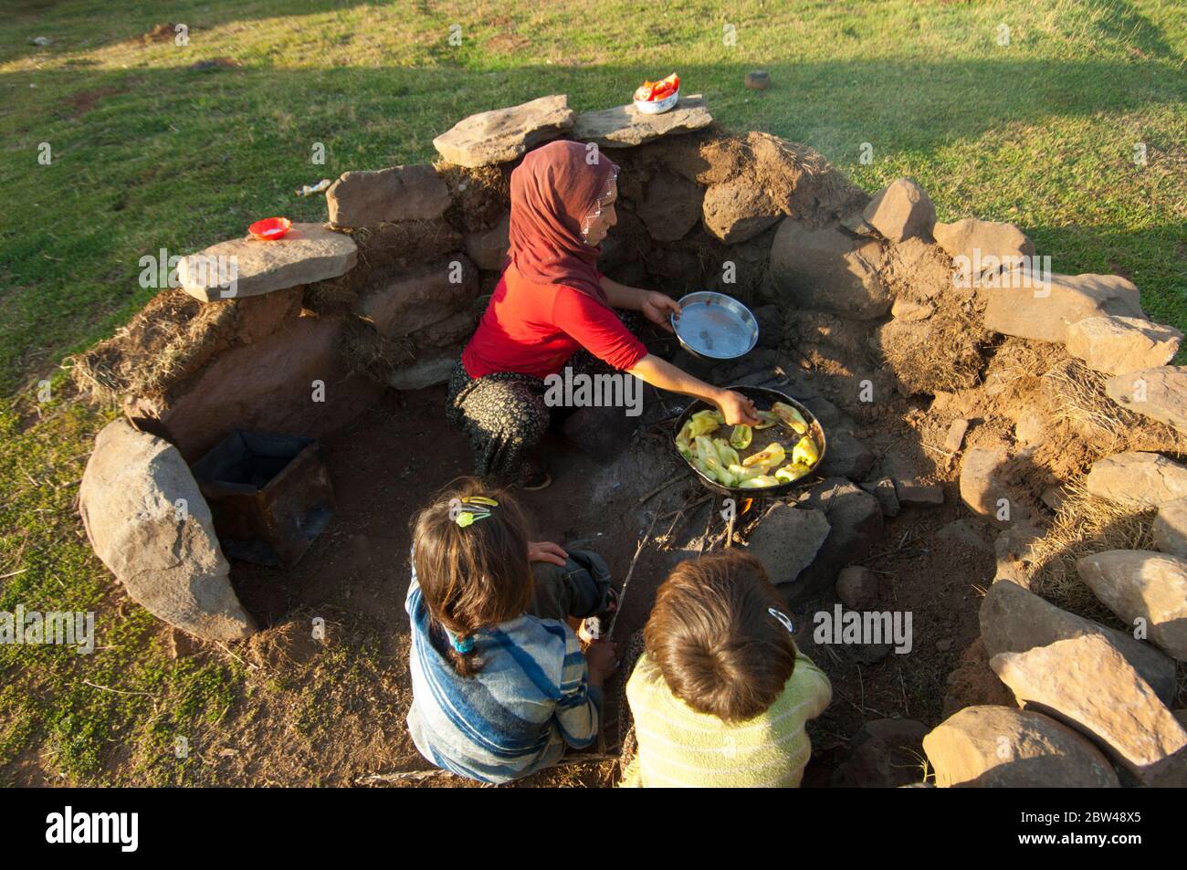 Türkei, Provinz Bingöl, Frau vom Stamm der Beritan-Nomaden an Feuerstelle beim Zubereiten von Essen auf einer Hochweide in den Seraferettin-Berg Foto Stock