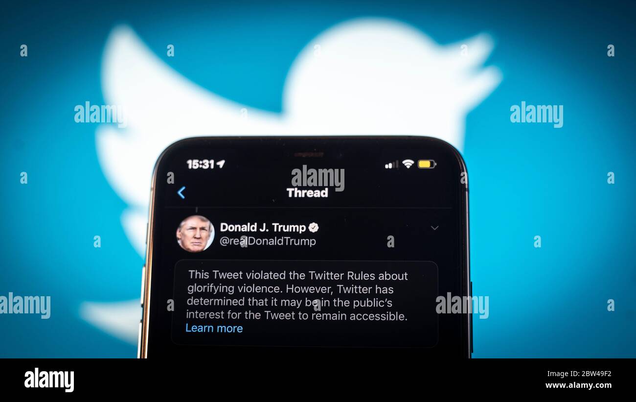 Un tweet del presidente americano Donald Trump è visto come incitare la violenza da Twitter in questa illustrazione fotografica su un iPhone Apple a Varsavia, Polonia il 29 maggio 2020. Twitter il 29 maggio ha applicato un’etichetta di verifica dei fatti a un tweet di voto per posta del presidente americano Donald Trump che l’azienda considera fuorviante. Twitter ha recentemente iniziato a etichettare i tweet con le etichette di notifica pubblica e di controllo dei fatti. L'etichettatura del tweet di Trump sul tumulto dopo la morte di George Floyd ha visto il presidente firmare un ordine esecutivo mirato alla Communications Decency Act. Sezione 230 che Foto Stock