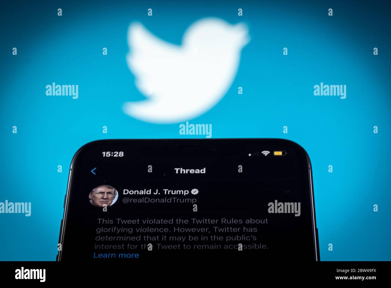 Un tweet del presidente americano Donald Trump è visto come incitare la violenza da Twitter in questa illustrazione fotografica su un iPhone Apple a Varsavia, Polonia il 29 maggio 2020. Twitter il 29 maggio ha applicato un’etichetta di verifica dei fatti a un tweet di voto per posta del presidente americano Donald Trump che l’azienda considera fuorviante. Twitter ha recentemente iniziato a etichettare i tweet con le etichette di notifica pubblica e di controllo dei fatti. L'etichettatura del tweet di Trump sul tumulto dopo la morte di George Floyd ha visto il presidente firmare un ordine esecutivo mirato alla Communications Decency Act. Sezione 230 che Foto Stock