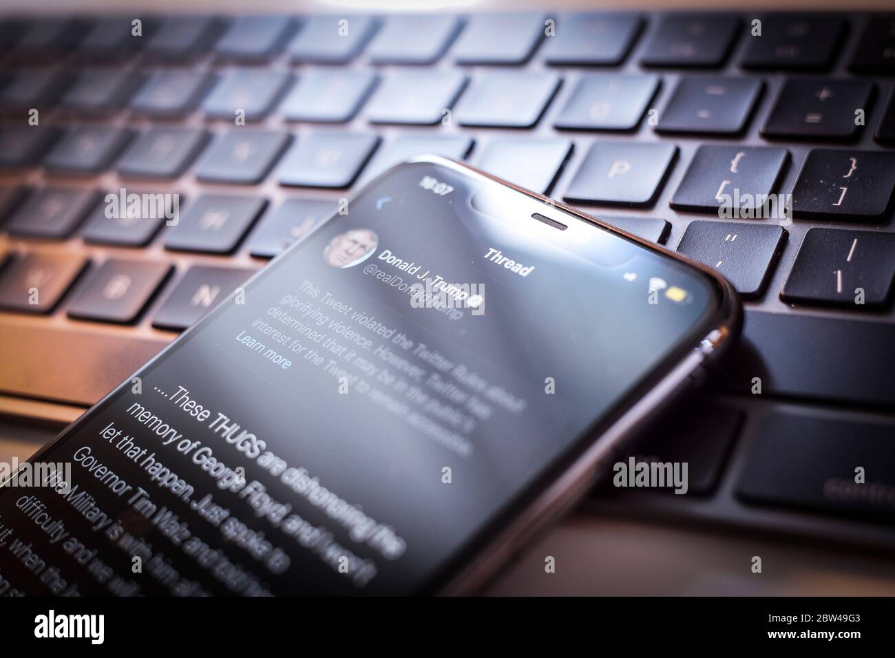Un tweet del presidente americano Donald Trump è visto come incitare la violenza da Twitter in questa illustrazione fotografica su un iPhone Apple a Varsavia, Polonia il 29 maggio 2020. Twitter il 29 maggio ha applicato un’etichetta di verifica dei fatti a un tweet di voto per posta del presidente americano Donald Trump che l’azienda considera fuorviante. Twitter ha recentemente iniziato a etichettare i tweet con le etichette di notifica pubblica e di controllo dei fatti. L'etichettatura del tweet di Trump sul tumulto dopo la morte di George Floyd ha visto il presidente firmare un ordine esecutivo mirato alla Communications Decency Act. Sezione 230 che Foto Stock