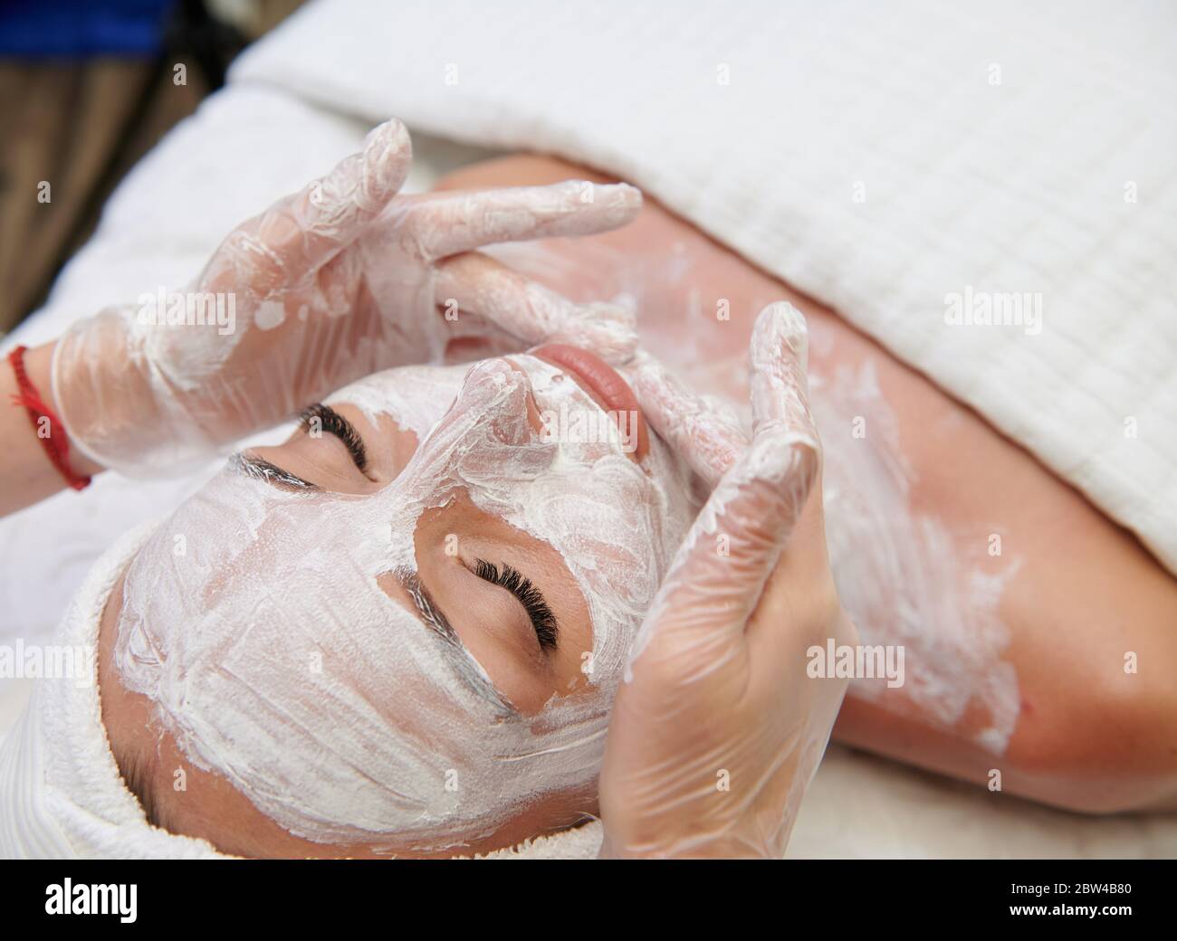 Donna con maschera facciale bianca in trattamento termale medicina alternativa Foto Stock