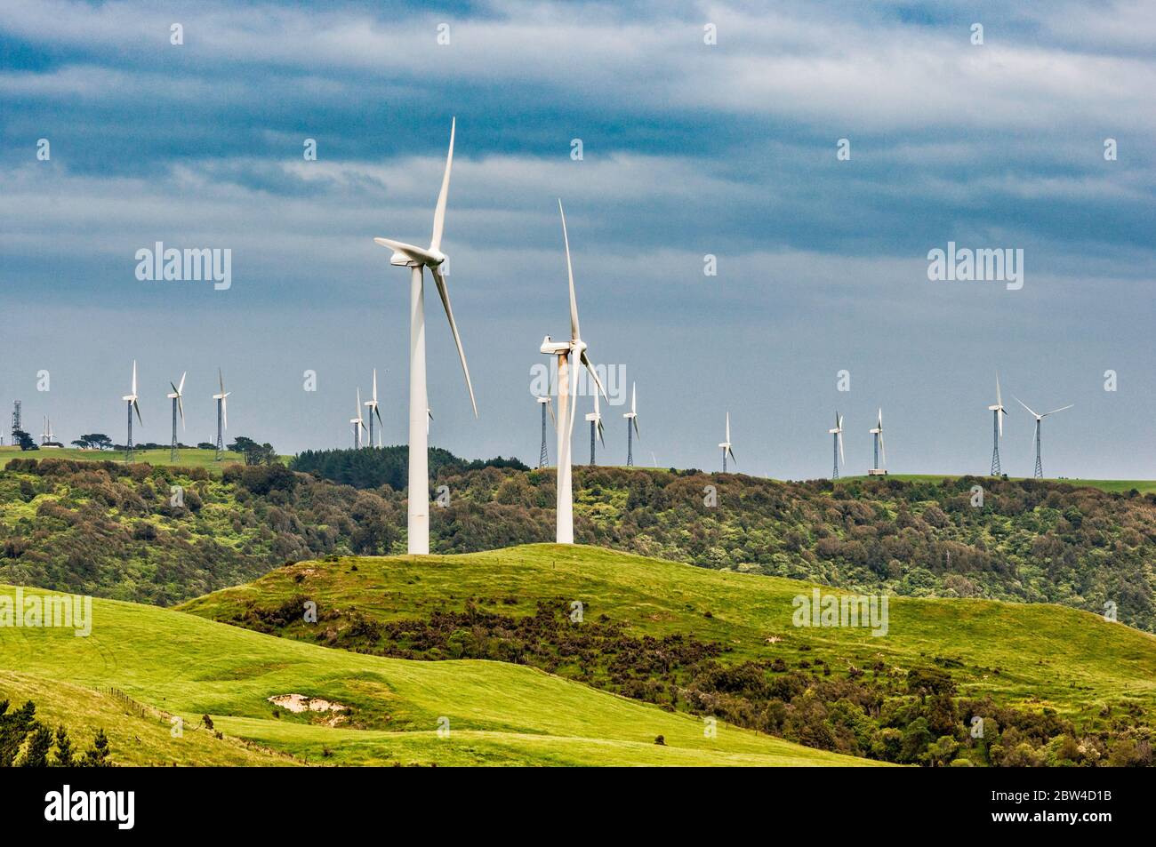 Turbine eoliche presso la fattoria eolica te Apiti, la fattoria di Tararua in lontananza, attraverso la gola di Manawatu, Saddle Road, la regione di Wanganui, l'isola del Nord, la Nuova Zelanda Foto Stock