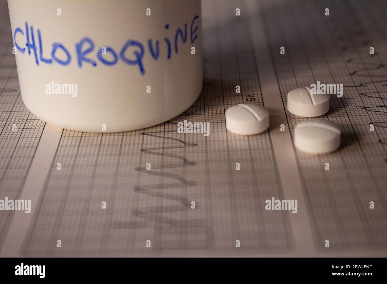 Effetti avversi sul cuore da parte di idrossiclorochina o clorochina. Pillole su un elettrocardiogramma con aritmie cardiache. Contenitore bianco con 'idro Foto Stock