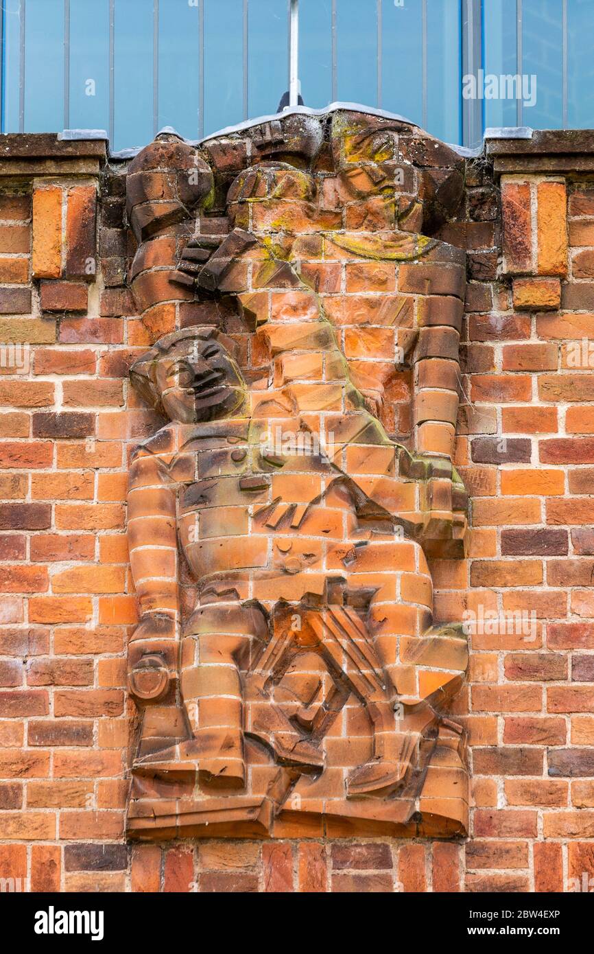 Una scultura in rilievo in mattoni reciso che rappresenta 'Jollity' sulla parete nord del RSC Shakespeare Theatre a Stratford Upon Avon, Inghilterra Foto Stock