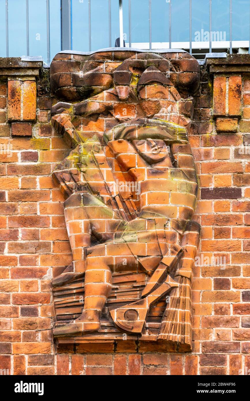Una scultura in rilievo in mattoni reciso che rappresenta il "tradimento" sulla parete nord del RSC Shakespeare Theatre di Stratford Upon Avon, Inghilterra Foto Stock
