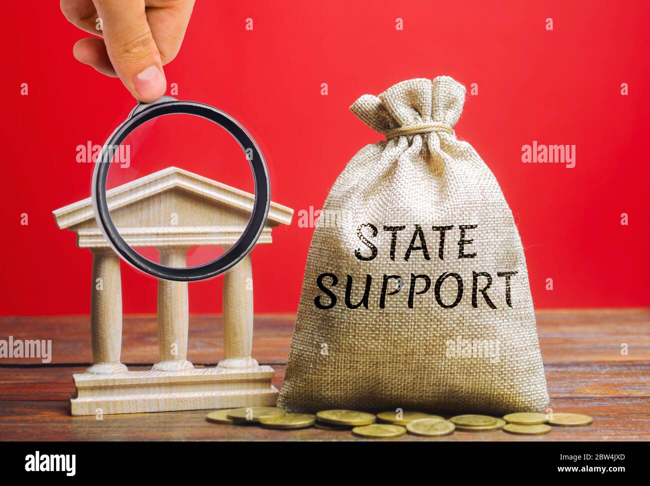 Borsa di denaro con la parola Stato sostegno e la banca edificio. Sgravi fiscali. Protezione dei produttori sul mercato interno e promozione in m estero Foto Stock