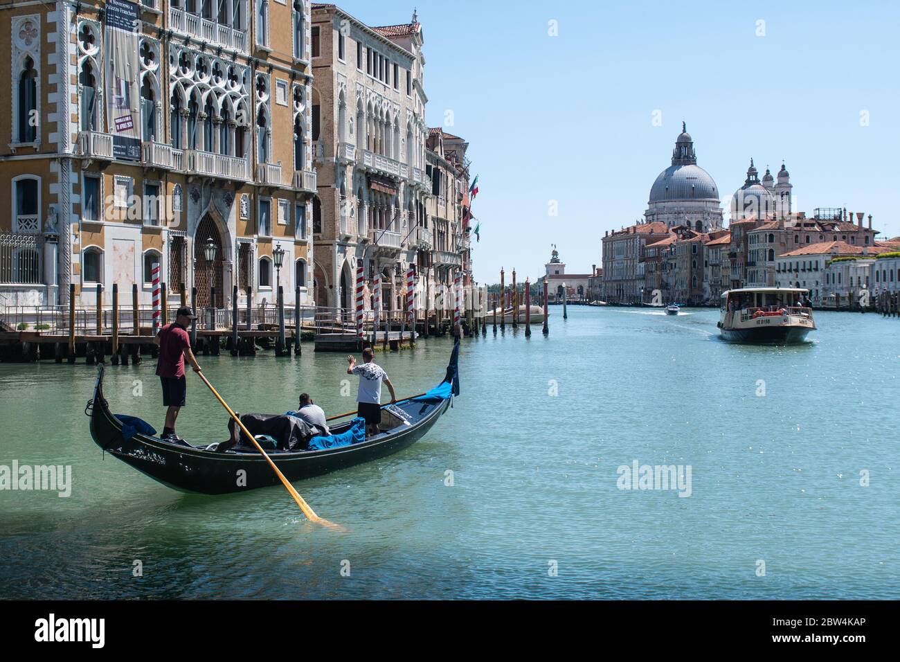 VENEZIA, ITALIA - MAGGIO 2020: Giovani gondolieri si allenano su un Canal Grande vuoto subito dopo la riapertura dopo il blocco per Covid-19 il 2020 maggio a V. Foto Stock