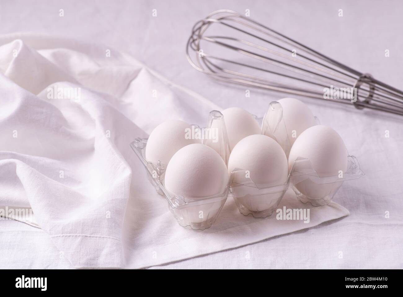 sulla tovaglia di lino bianco, in primo piano, uova bianche fresche pronte per la preparazione di ricette culinarie fatte in casa Foto Stock