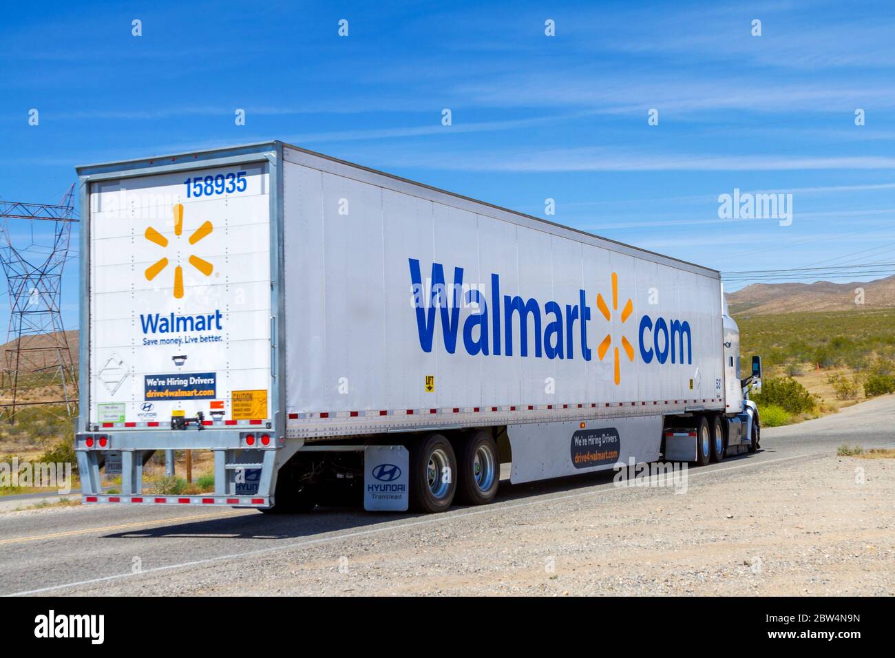 Apple Valley, CA / USA – 16 maggio 2020: Un rimorchio per semi-camion Walmart su una strada nel deserto del Mojave in Apple Valley, California. Foto Stock