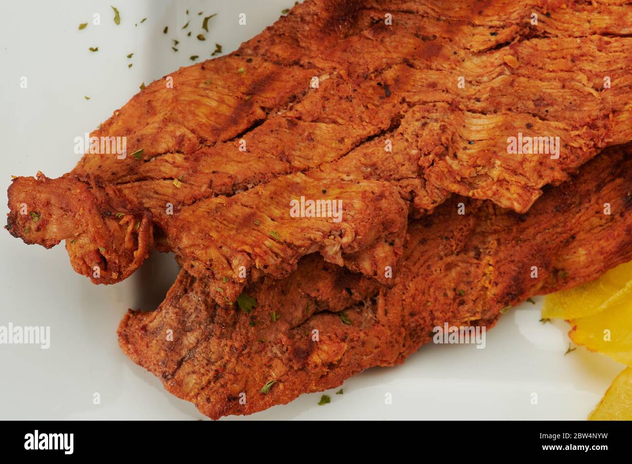 Carne marrone fritta su piastra bianca vista ravvicinata Foto Stock