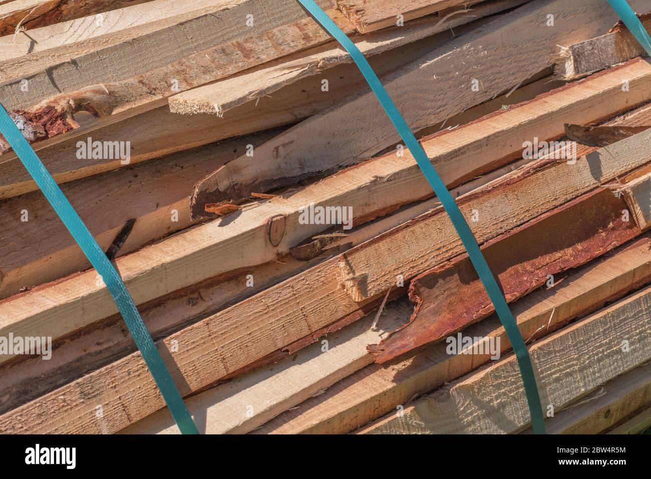 Cumulo di scarti di legname di segheria al sole. Metafora industria del legno britannico, Segherie, riciclaggio legno, scarti. Foto Stock