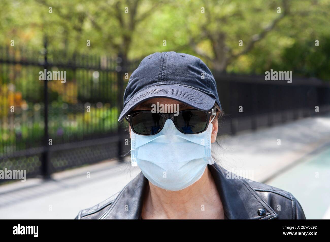 Testa e spalla Ritratto di Donna mid-adult indossare maschera protettiva all'aperto Foto Stock