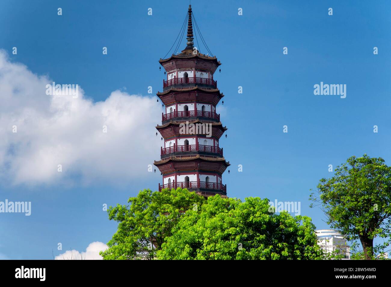 Chigang Pagoda che sorge sopra gli alberi contro un cielo blu vicino a un edificio di appartamenti in Guangzhou Cina, provincia di Guangdong. Foto Stock