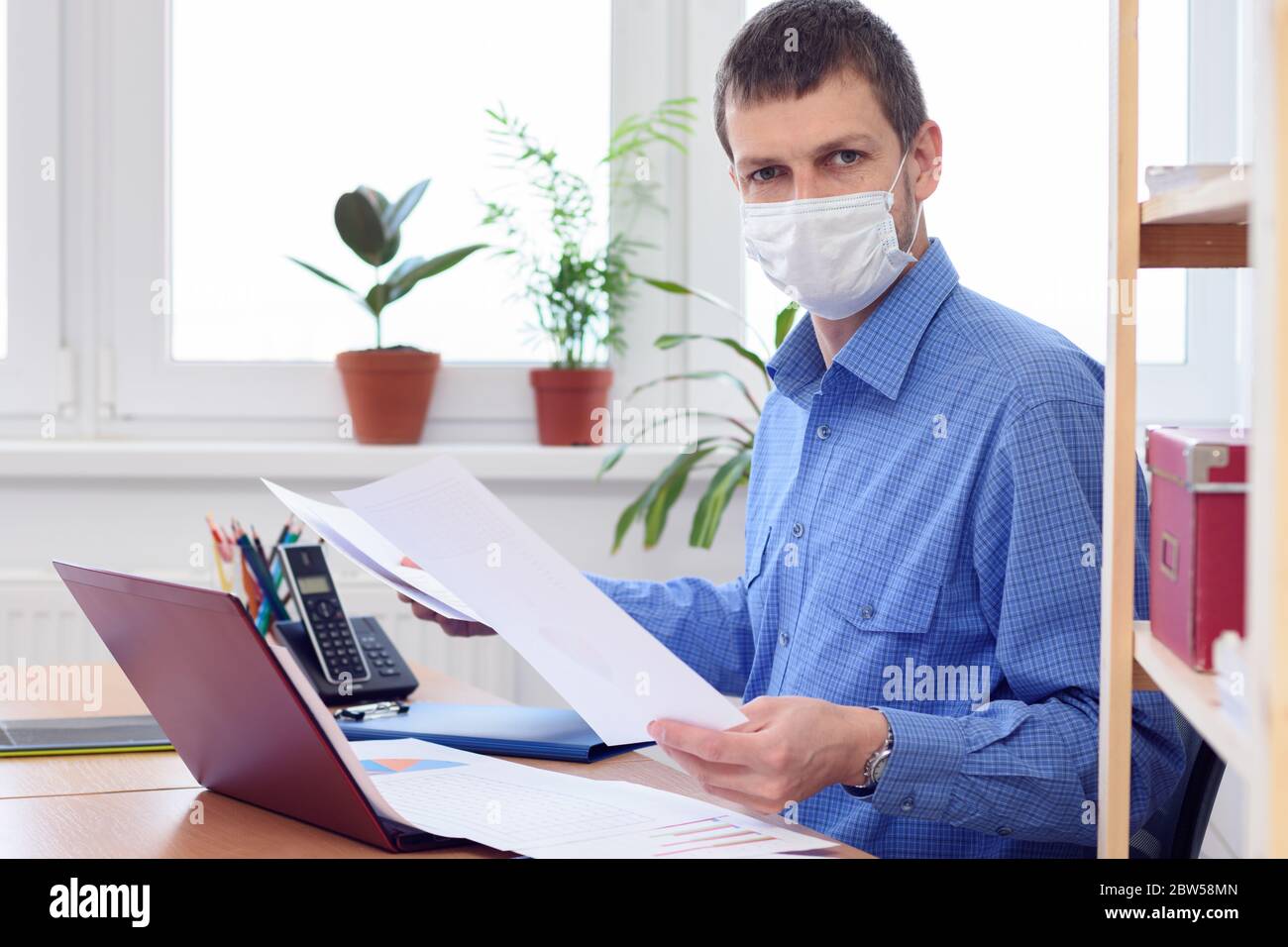 una persona in un ufficio sul posto di lavoro sta studiando i dati nei documenti Foto Stock