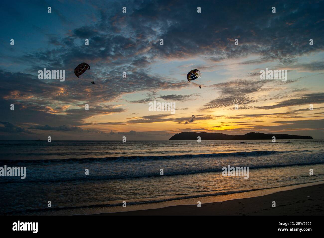 Paracadutismo al tramonto sull'isola Foto Stock