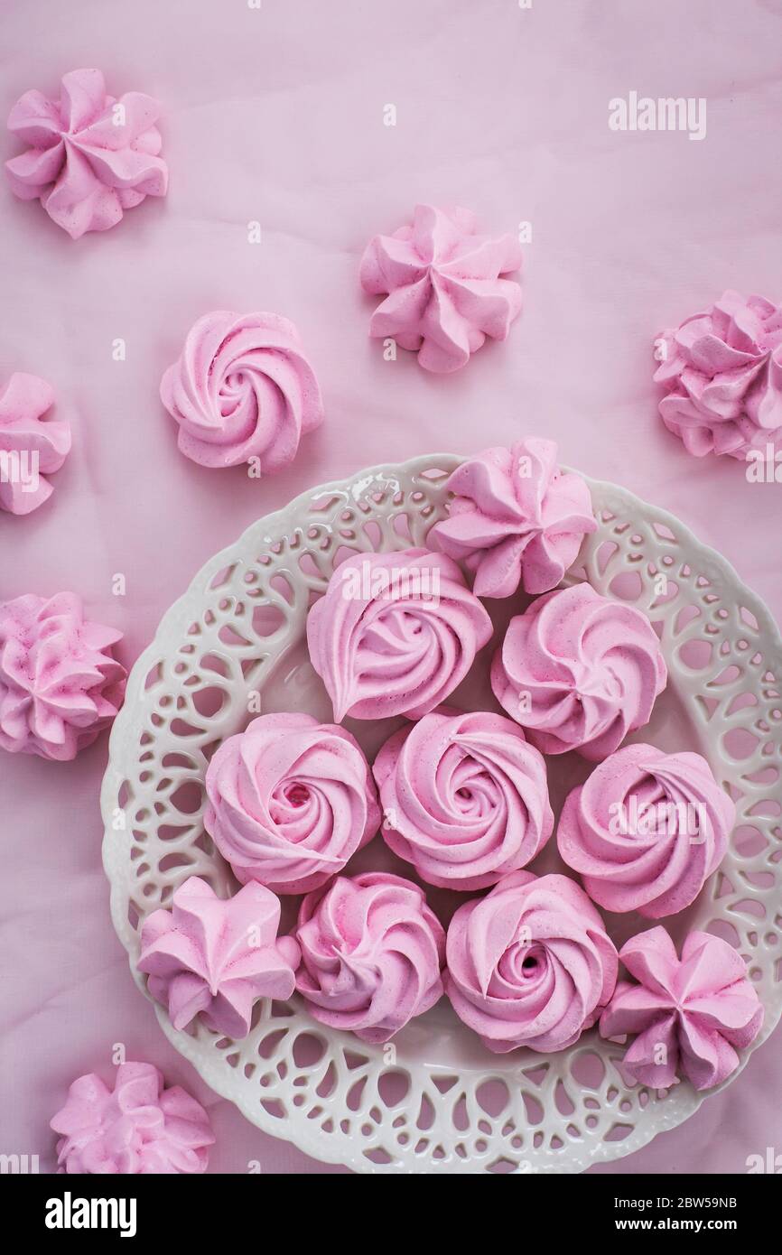 Meringhe rosa su piatto, sfondo colorato, vista dall'alto Foto Stock