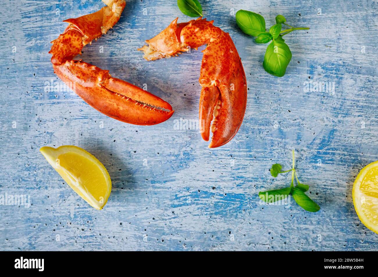Una cena costosa a base di pesce appena servita con pasto cotto di aragosta artiglio e limone Foto Stock