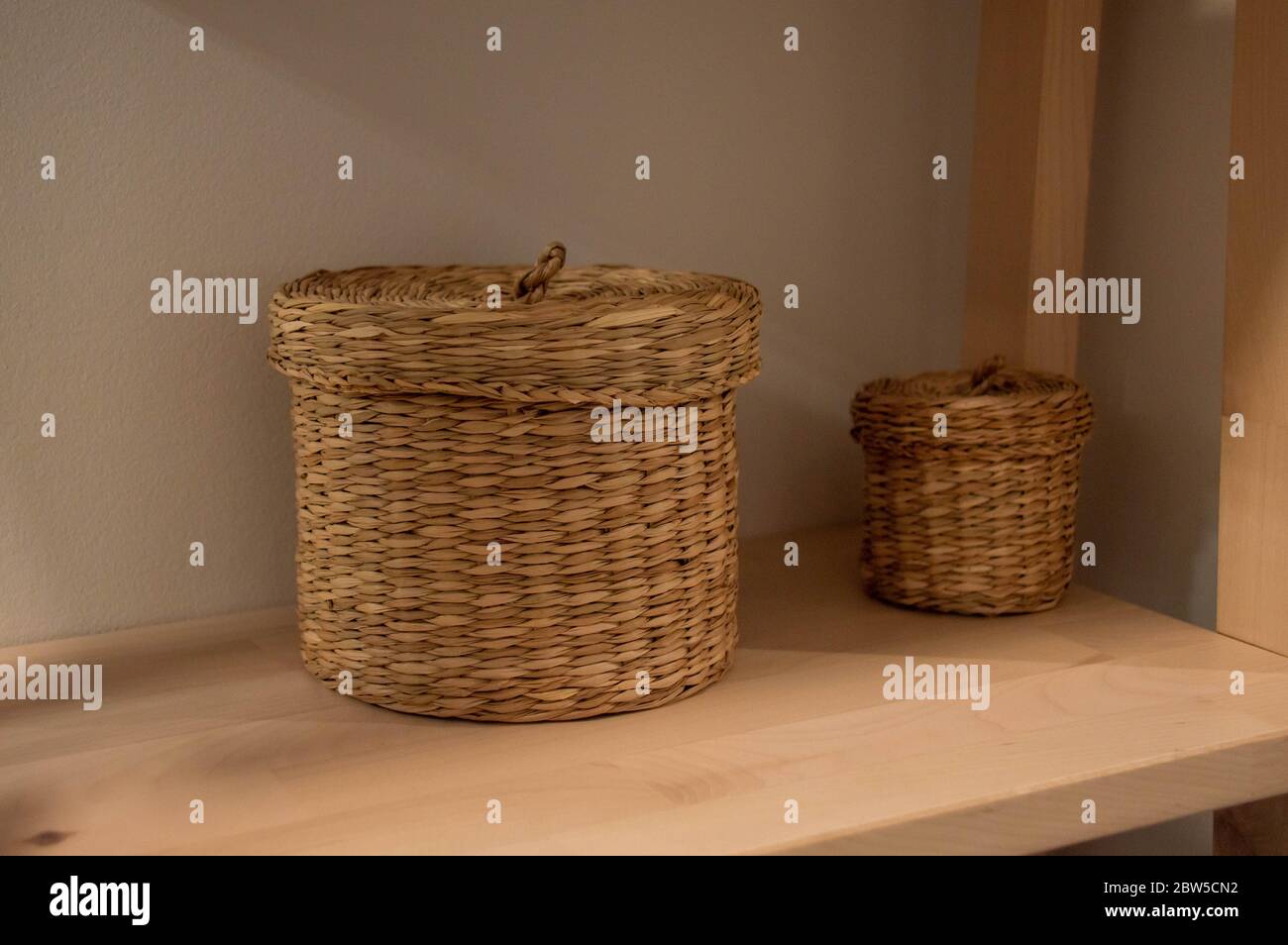 Cestelli di vimini su una mensola di legno. Accessori per interni. Foto Stock