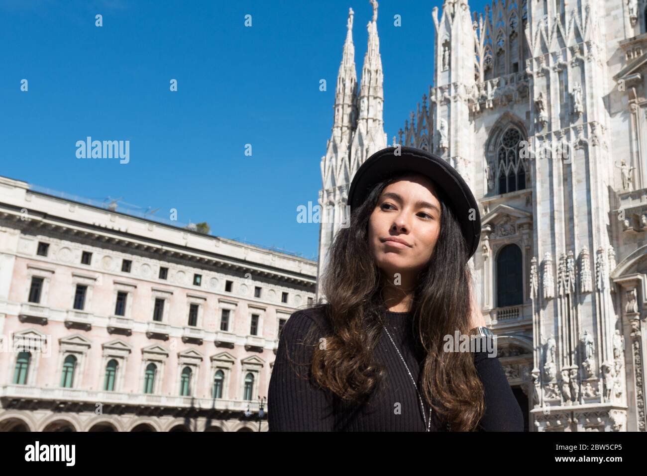 Immagine orizzontale della giovane donna di brunetta che si posa davanti al Duomo di Milano, in Italia Foto Stock
