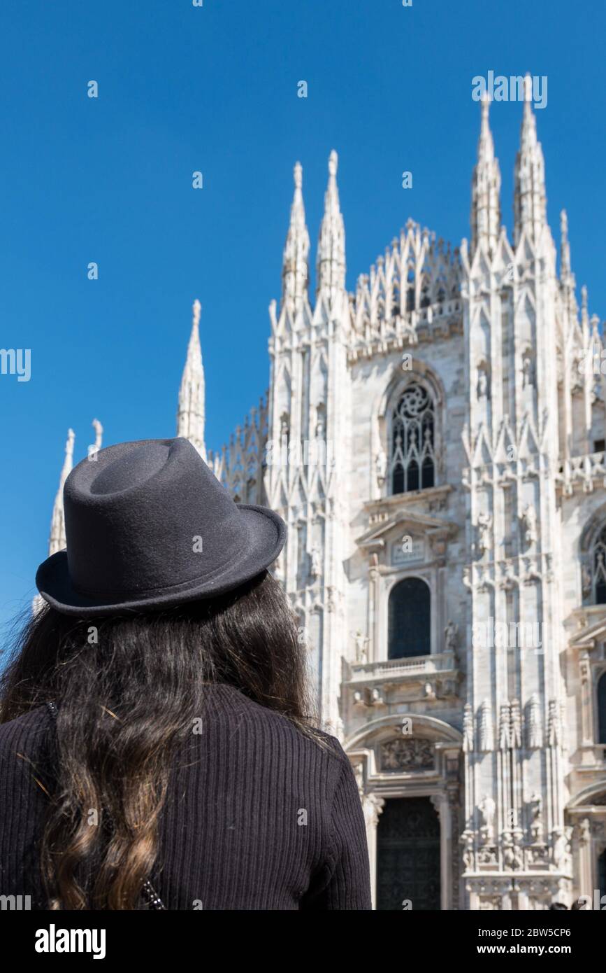 Immagine verticale di giovane donna brunetta che guarda al Duomo di Milano, Italia Foto Stock