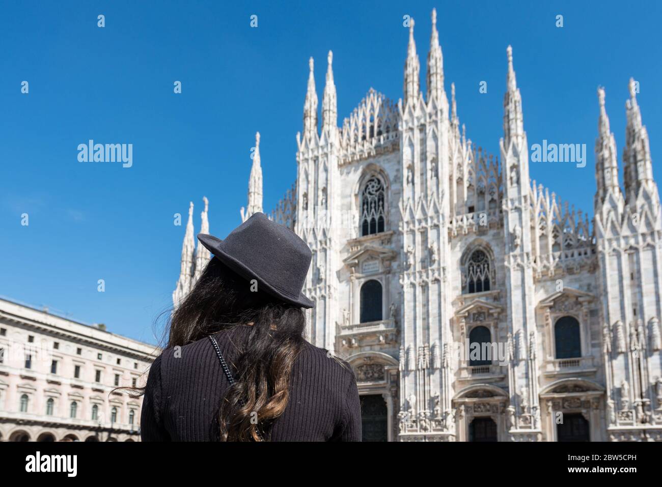 Immagine grandangolare di giovane donna bruna che guarda al Duomo di Milano, Italia Foto Stock