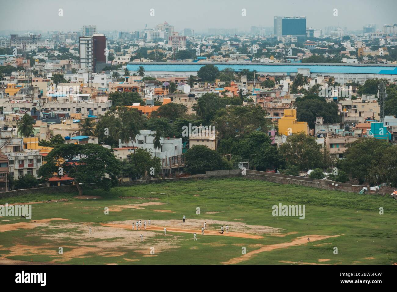 Uomini che giocano a cricket in alcuni campi a Chennai, India Foto Stock