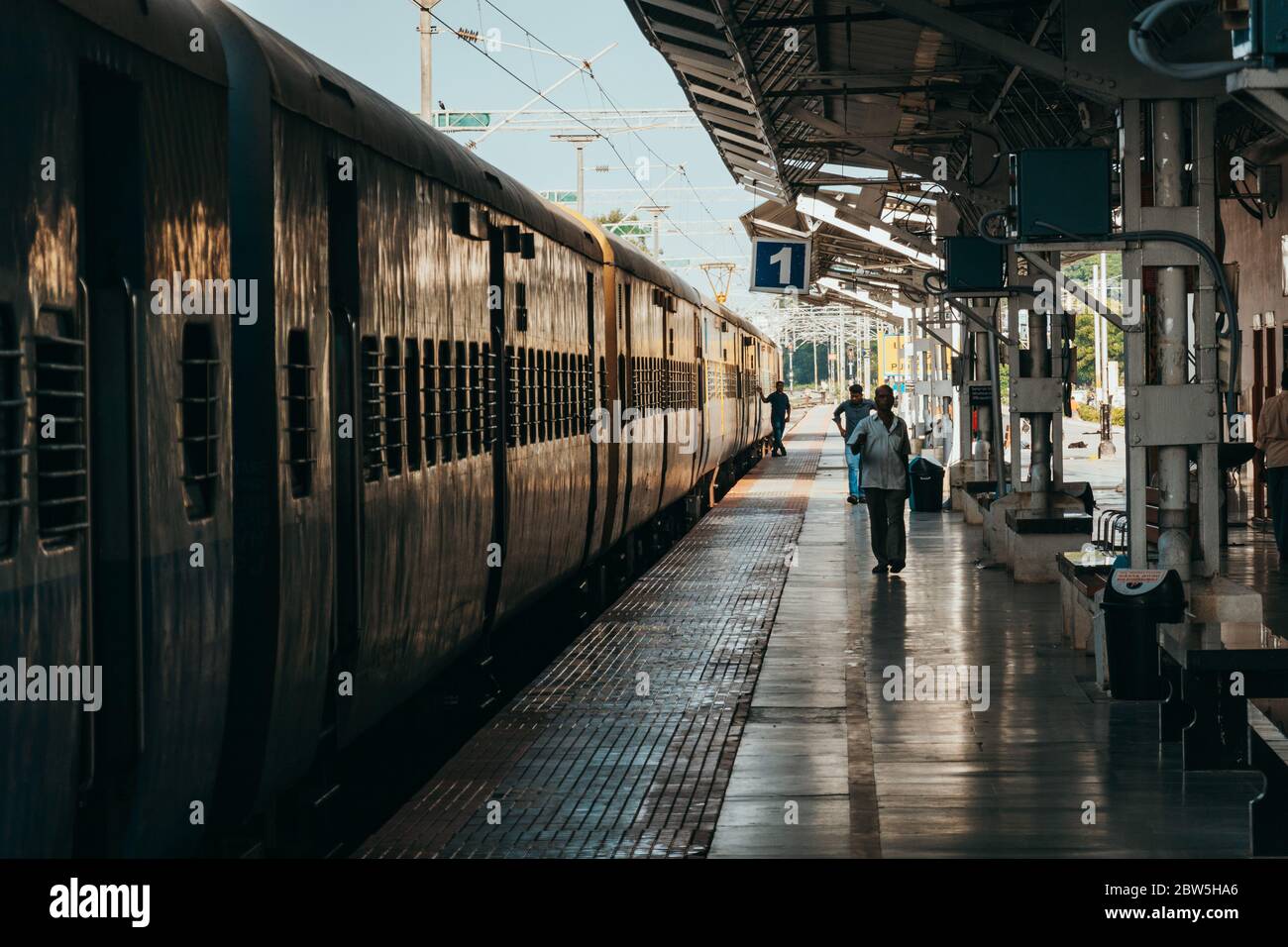 Le Ferrovie indiane trainano le carrozze ad una piattaforma relativamente vuota della stazione di Puducherry, in una mattina presto Foto Stock