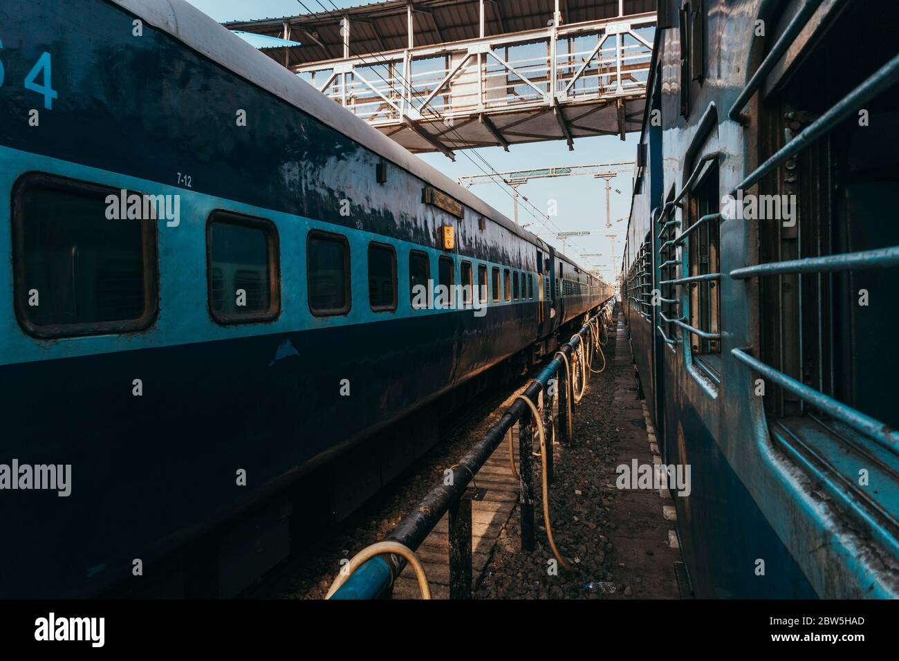 Le Ferrovie indiane trainano le carrozze alla stazione di Puducherry, in una mattina presto. Un tubo dell'acqua e un tubo flessibile si snoda tra loro Foto Stock