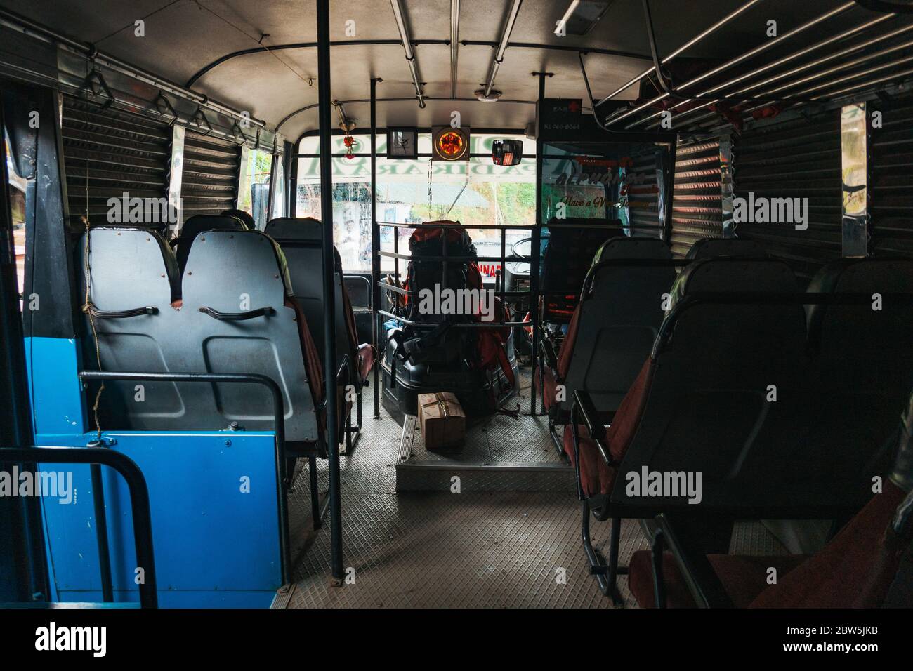 A bordo di uno dei famigerati autobus a serranda di Munnar. Non hanno finestre di vetro, solo persiane che si rotolano verso il basso quando piove Foto Stock
