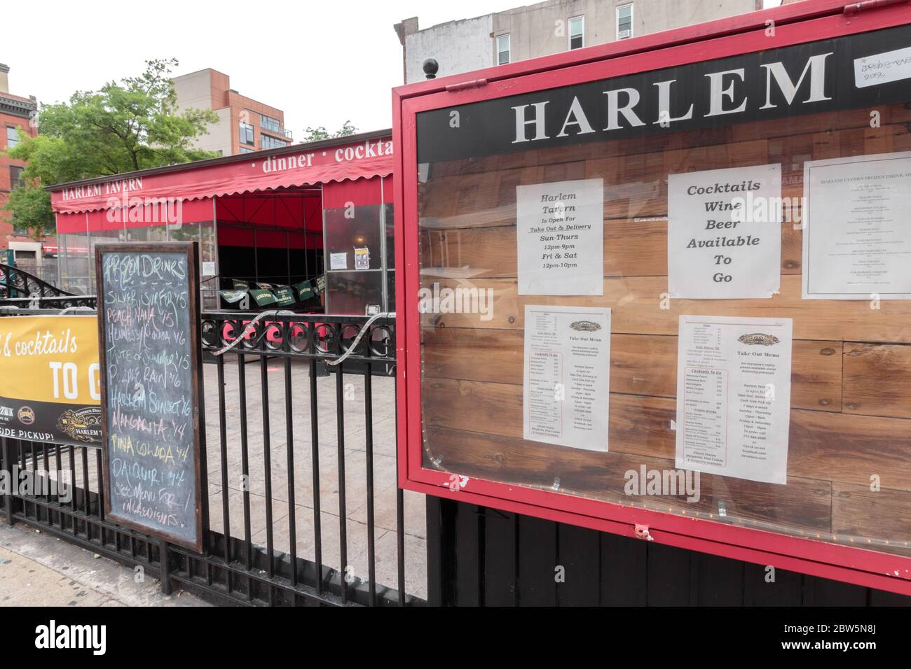 I cartelli di fronte alla Harlem Tavern offrono servizio di take-out e consegna e birra, vino e cocktail da consumare durante il coronavirus o la pandemia del covid-19 Foto Stock