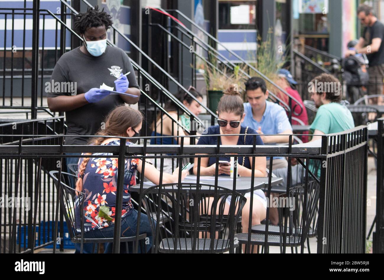 Washington, Stati Uniti. 29 maggio 2020. Un cameriere prende un ordine in un ristorante nel quartiere Adams Morgan di Washington, DC il 29 maggio 2020. La regione della metropolitana DC sta iniziando a riaprirsi con i locali da pranzo all'aperto dopo quasi tre mesi di blocco a causa della pandemia COVID-19. Foto di Kevin Dietsch/UPI Credit: UPI/Alamy Live News Foto Stock