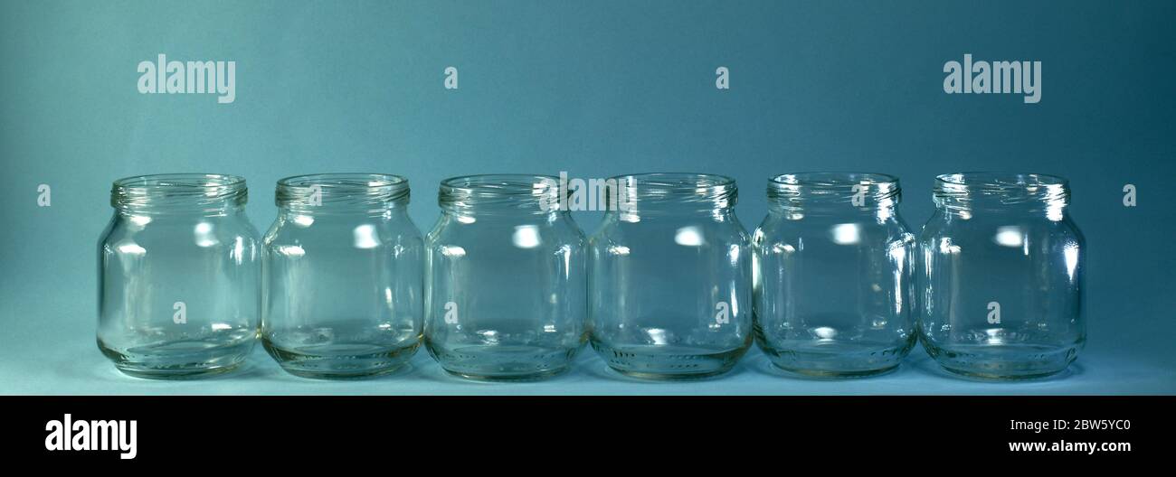 Fila orizzontale di vasi trasparenti su sfondo blu con un'ampia baner. Foto Stock