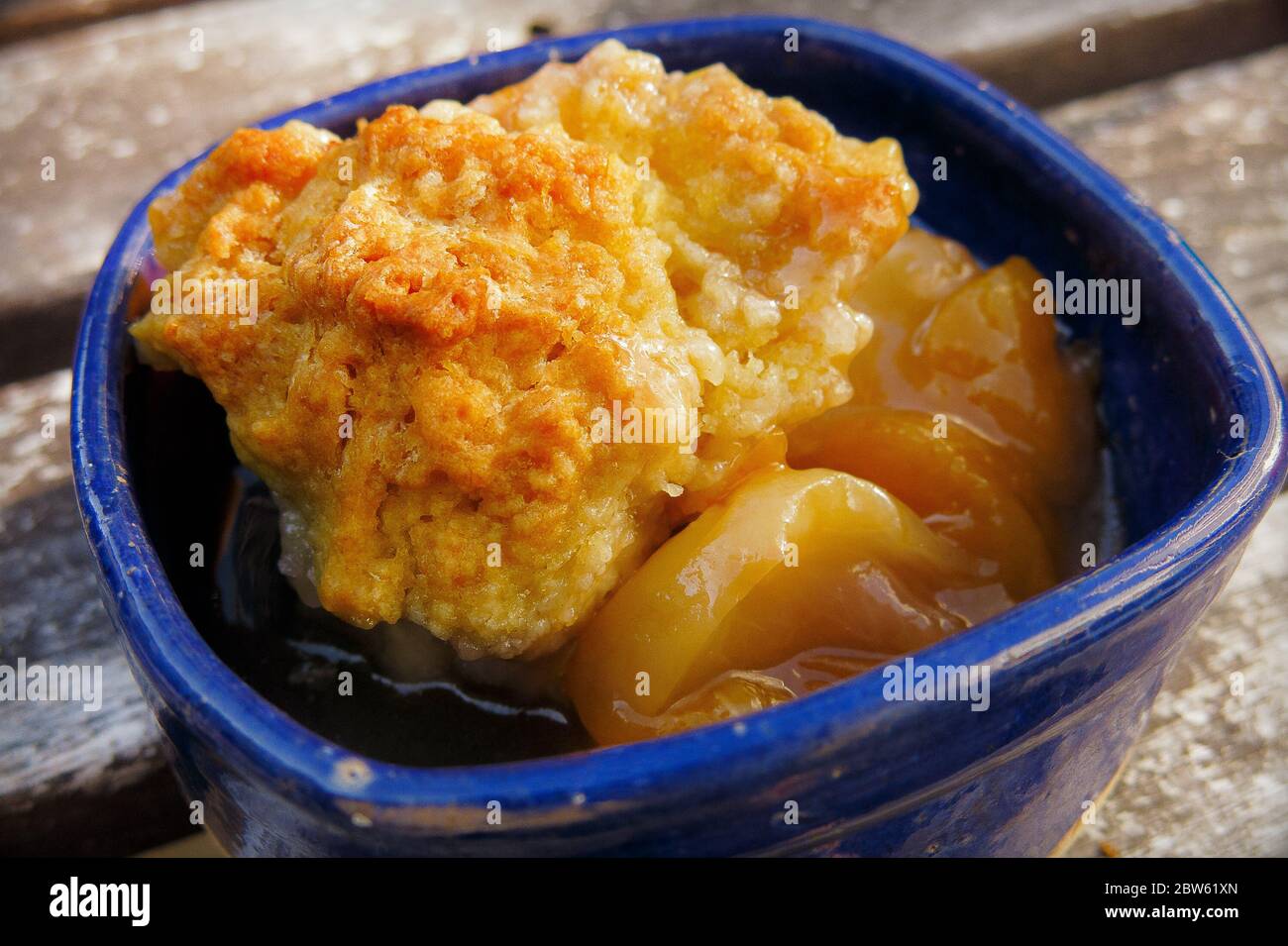 Primo piano di Peach e Biscuit Dessert in Blue Bowl Foto Stock