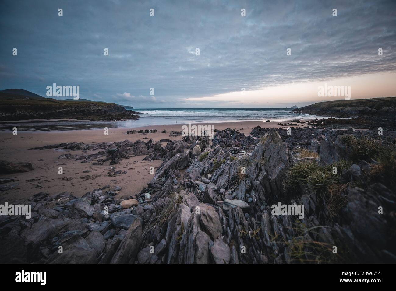 Un tramonto su una spiaggia rocciosa nell'Irlanda del sud. Foto Stock