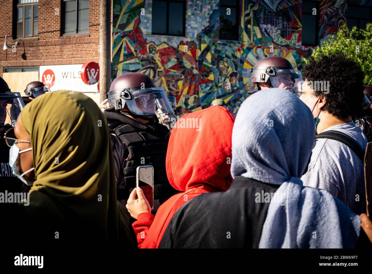 gli ufficiali di polizia di pattuglia dello stato stanno in guardia contro le rivolte di minneapolis e controllano i dimostranti e i manifestanti vicini alla folla Foto Stock