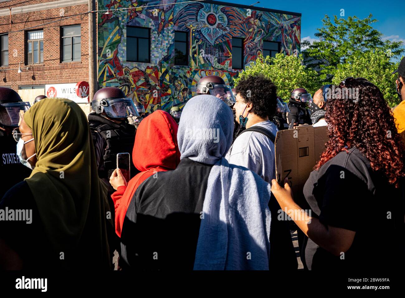 gli ufficiali di polizia di pattuglia dello stato stanno in guardia contro le rivolte di minneapolis e controllano i dimostranti e i manifestanti vicini alla folla Foto Stock