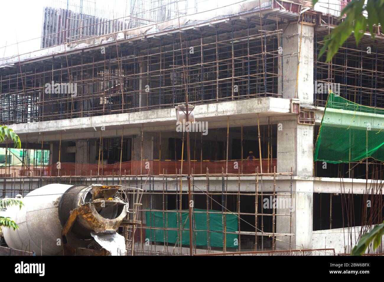 Primo piano di edifici commerciali in costruzione con operai edili. Foto Stock