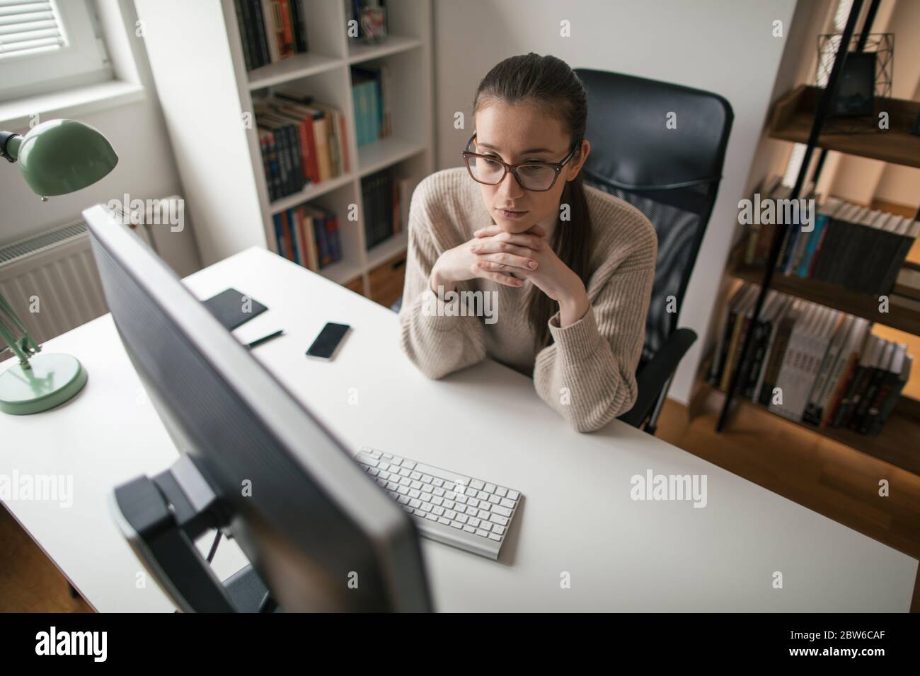 Giovane donna d'affari che lavora a lunghe ore dall'ufficio domestico Foto Stock