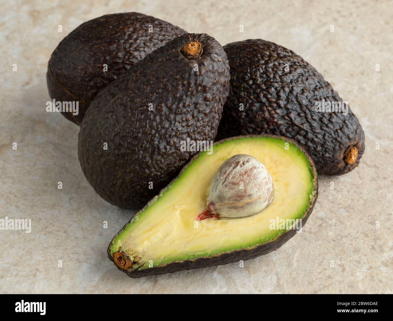 Avocado di hass maturo intero e mezzo fresco Foto Stock