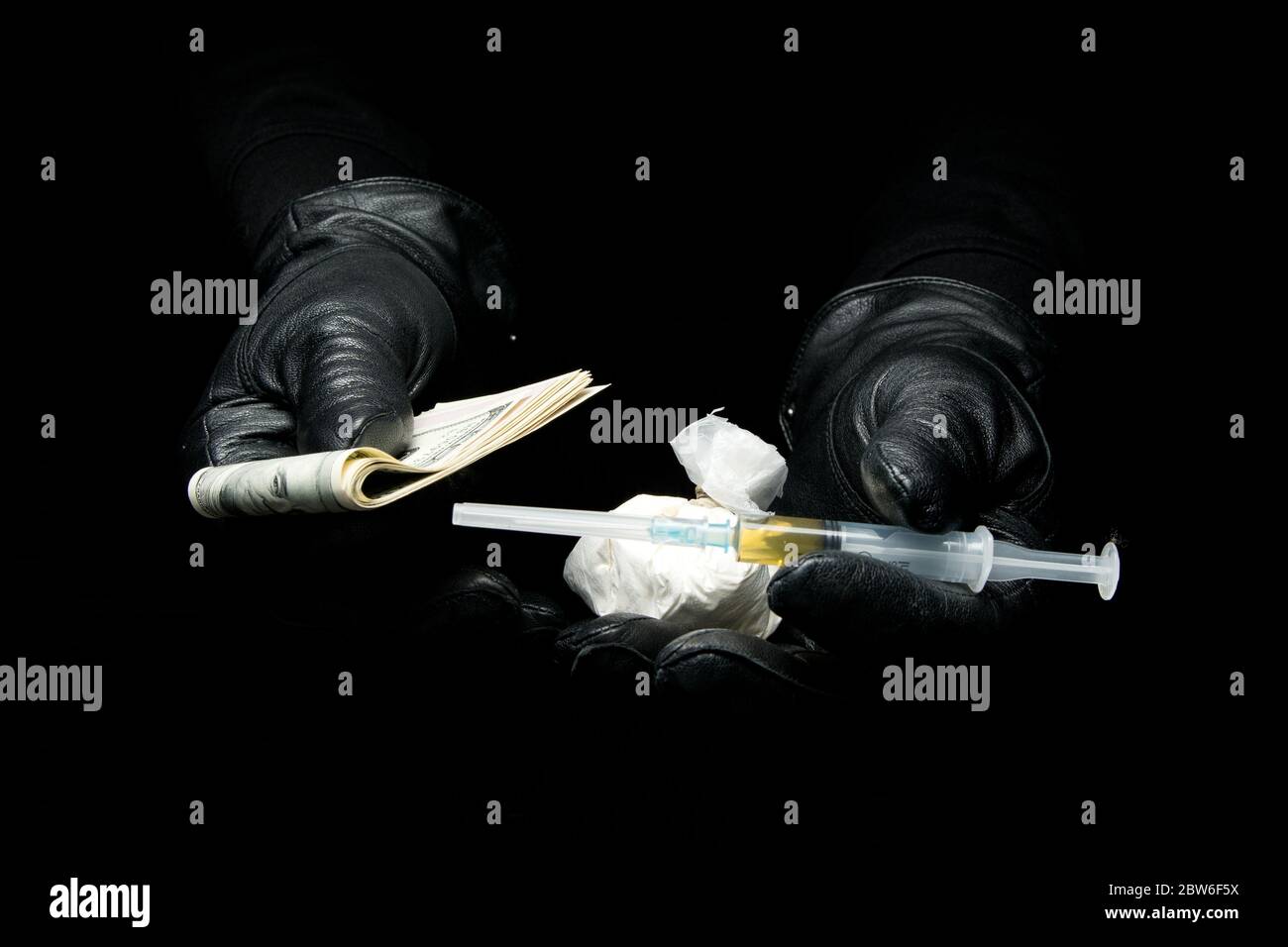 mani gugorate che tengono fuori le droghe e il denaro, primo piano Foto Stock